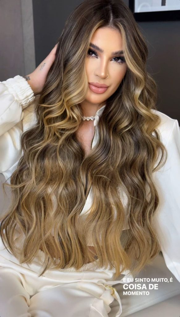 Model with shiny sandy brown hair styled in loose waves under sunlight

