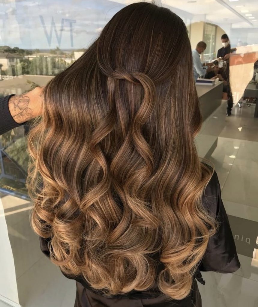  Model with shiny sandy brown hair styled in loose waves under sunlight

